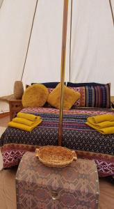 - 2 lits avec des oreillers jaunes et une valise dans une chambre dans l'établissement The Tent, à Güime