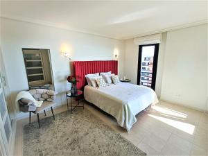 Un dormitorio con una cama grande y un cabecero rojo. en Luxury Los Gigantes Apartment, en Puerto de Santiago 16 fotos más