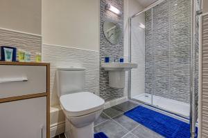 a bathroom with a toilet and a shower and a sink at K Suites - The Villas in Birmingham