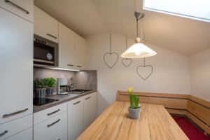 een keuken met een houten tafel en harten aan de muur bij Ferienwohnung Laux in Oberstdorf
