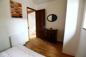 a bedroom with a bed and a mirror and a door at LA MAISONNETTE DU POTIER in Caunes-Minervois