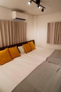 - une chambre avec 2 lits et des oreillers jaunes dans l'établissement Liaison Court Universal Gateway - Free Parking, à Osaka