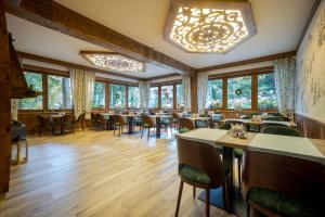 Un restaurante con mesas y sillas y una lámpara de araña. en Willa Maria 4, en Zakopane