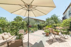 a patio with a table and an umbrella at Ginevra Home in Monterosi