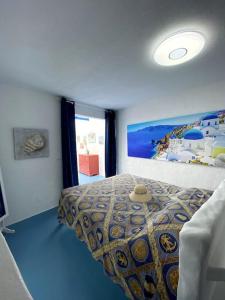 Un dormitorio con una cama y un cuadro en la pared. en Casa Santorini, en Ribeira Brava