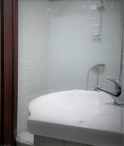 uma casa de banho branca com um lavatório e um chuveiro em Casa de sus em Brasov