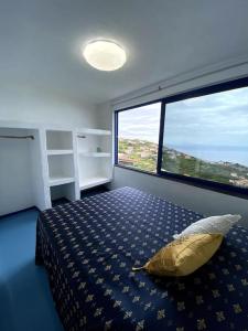 Un dormitorio con una cama y una ventana grande en Casa Santorini, en Ribeira Brava