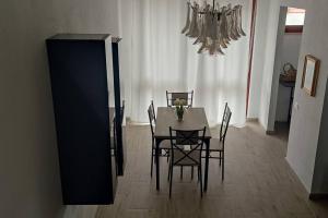 a dining room with a table and chairs and a chandelier at NiMa in Cagliari +20 photos