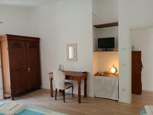 Habitación con mesa de madera y silla blanca. en Sorgenti nel bosco Appartamento vista lago, en Campo Reggiano