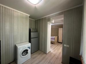 uma lavandaria com máquina de lavar e secar roupa em Однокомнатная квартира напротив Аэропорта Алматы em Turksib
