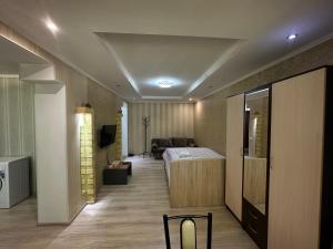 ein Schlafzimmer mit einem Bett und einem Sofa in einem Zimmer in der Unterkunft Однокомнатная квартира напротив Аэропорта Алматы in Turksib