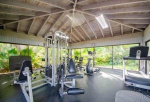 a gym with treadmills and exercise equipment and windows at Poolside Breeze Retreat in Key West