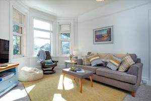 a living room with a couch and a table at Pebbles In Budleigh in Budleigh Salterton