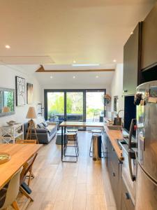 タロワールにあるLe Loft à deux pas du Lacのテーブルと椅子のあるキッチンとリビングルーム +7枚の写真