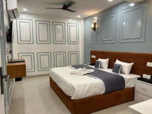 um quarto com uma cama grande e um tecto em Hotel Cosmopolitan Rooms & Banquet em Allahabad