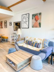 タロワールにあるLe Loft à deux pas du Lacの青いソファとテーブルのあるリビングルーム