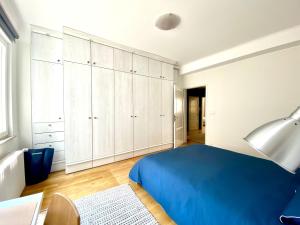 1 dormitorio con 1 cama azul y armarios blancos en Bars & Culture At Your Doorstep, For Party People!, en Luxemburgo