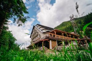 a building in the middle of a field of grass at Bâlea Cascadă in Cîrţişoara