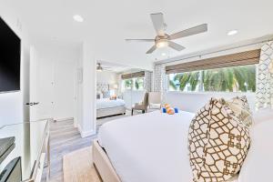 a white bedroom with a large bed and a tv at Balboa Island Diamond Resort Compound in Newport Beach