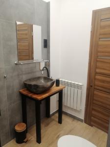 a bathroom with a bowl sink on a wooden table at Karkonoskie Cztery Kąty in Karpacz