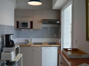 a kitchen with white cabinets and a microwave at Appartement Trégastel: Vue mer, Parking privé, Petit chien admis. - FR-1-542-5 in Trégastel