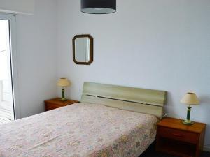 a bedroom with a bed and two lamps and a mirror at Appartement Trégastel: Vue mer, Parking privé, Petit chien admis. - FR-1-542-5 in Trégastel