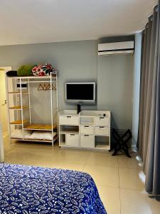 sypialnia z łóżkiem i telewizorem na komodzie w obiekcie Departamento en el Centro de Recoleta con pileta, parrilla, gym y laundry w BuenosAires