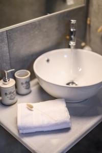 Dalie Luxury Suites في جوفيا: حمام مع حوض ومنشفة بيضاء