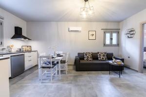 a kitchen and a living room with a couch and a table at Dalie Luxury Suites in Gouvia