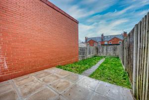 a brick wall with a yard with a fence at K Suites - Madeley Road in Birmingham