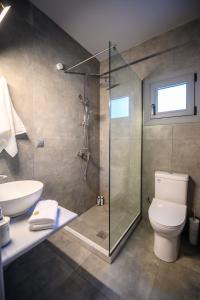 a bathroom with a shower and a toilet and a sink at Dalie Luxury Suites in Gouvia