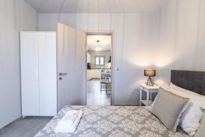 a bedroom with a bed and a door leading to a kitchen at Dalie Luxury Suites in Gouvia