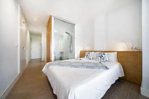 una camera bianca con un grande letto bianco con cuscini di Estudio con terraza vista mar a Las Palmas de Gran Canaria