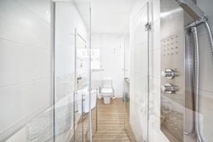 a white bathroom with a shower and a toilet at Estudio con terraza vista mar in Las Palmas de Gran Canaria