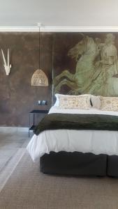 una camera da letto con un letto grande con un dipinto sul muro di Bannockburn Guest Cottage a White River