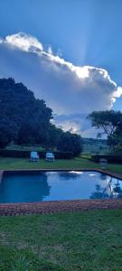 una piscina d'acqua con due panchine in un parco di Bannockburn Guest Cottage a White River