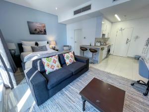 a living room with a couch and a kitchen at Studio 1101 iTower in Gaborone