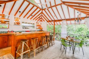 a kitchen with a wooden bar and green chairs at Lost Pools Bungalows in Ojochal