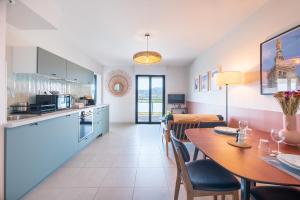 een keuken en eetkamer met een tafel en stoelen bij Prado Beach - Appt avec terrasse in Marseille