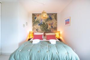 a bedroom with a blue bed with red pillows at Prado Beach - Appt avec terrasse in Marseille