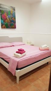 a bedroom with a bed with pink sheets and a painting at Appartamento Borgonuovo in Gallipoli