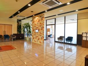 a lobby with chairs and a pillar in a building at Hotel New Gaea Itoshima in Itoshima