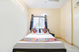 uma cama num quarto com uma janela em FabExpress Shivsai Palace em Kharadi