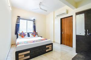 um quarto com uma cama e uma porta de madeira em FabExpress Shivsai Palace em Kharadi