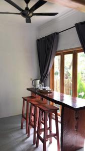 a dining room table with chairs and a ceiling fan at Bale Kebon Rangsot in Pawenang