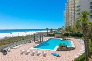 a swimming pool with chairs and the beach at White Caps 203 in Orange Beach
