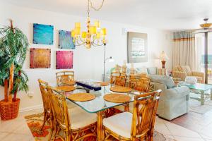 a dining room and living room with a table and chairs at White Caps 203 in Orange Beach