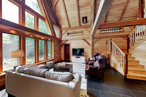 a living room with a couch and chairs in a cabin at The Lazy Lumberjack Cottages in Franklin