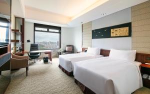 um quarto de hotel com duas camas e uma secretária em InterContinental Foshan, an IHG Hotel - Free Shuttle Bus for Canton Fair em Foshan