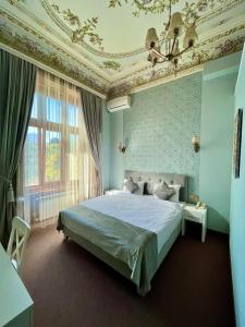 a bedroom with a bed with blue walls and a ceiling at Nizami Central Street Hotel in Baku